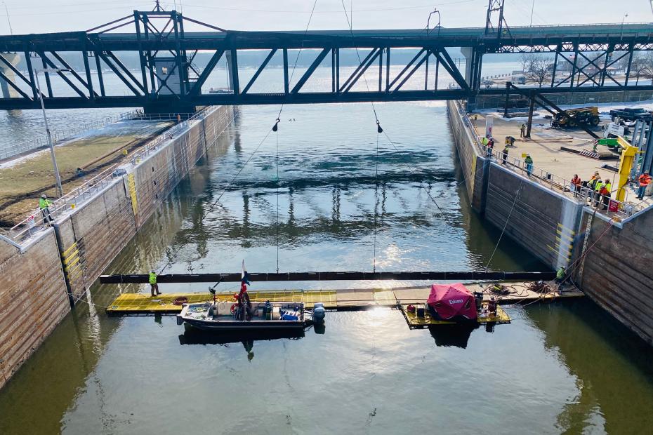 Photo of a the USGS's underwater deterrent project, showing tow boats in a canal with scaffolding in the water and under construction