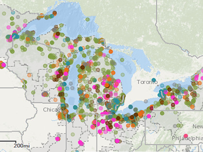 Map displaying the Great Lakes region, including Lake Superior, Lake Michigan, Lake Huron, Lake Erie, and Lake Ontario. The map is marked with various colored dots representing different data points or locations of GLRI projects per Focus Area around the lakes and surrounding areas. The dots are scattered across the map, indicating a wide distribution of data points throughout the region. Select the map to view the interactive version available via EPA ArcGIS.