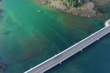 Area view of a car bridge over a river where a rapids restoration project is ongoing. 