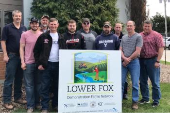 Photo of a group of men standing behind a sign for the Lower Fox Demonstration Farm Network.