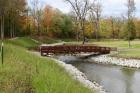 A bridge, repurposed from a multiuse trail that had to be relocated due to the State of Wisconsin's Highway KR expansion, now crosses the Pike River within the newly restored area within Kenosha County Parks' Petrifying Springs Park. Credit: Kenosha County Parks.