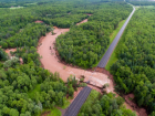 Fish Creek rages through a highway after washing out a bridge in the Father’s Day storm.