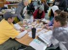 Several participants sit at a table during an invasive crayfish workshop.